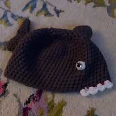 a knitted bear hat laying on the ground