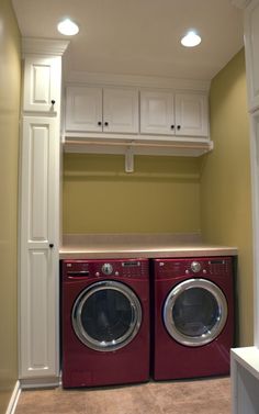 a red washer and dryer sitting in a laundry room next to each other