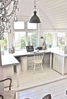 an image of a kitchen setting with white cabinets and counter tops, chandelier hanging from the ceiling