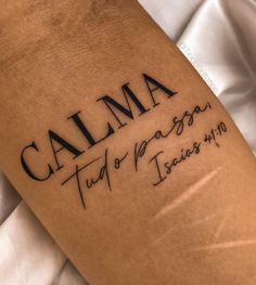 a close up of a person's arm with a tattoo that says, calma