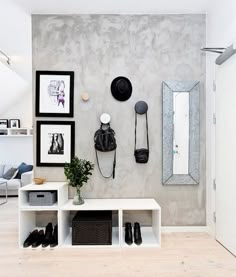 a white room with pictures on the wall and shoes hanging up against the wall next to it