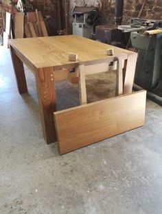 a wooden table sitting inside of a room next to a brick wall with tools on it