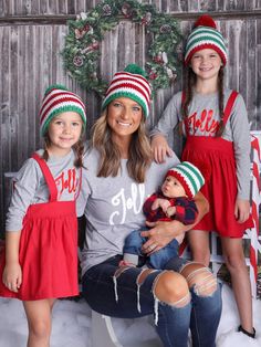 a woman and two children wearing matching christmas hats