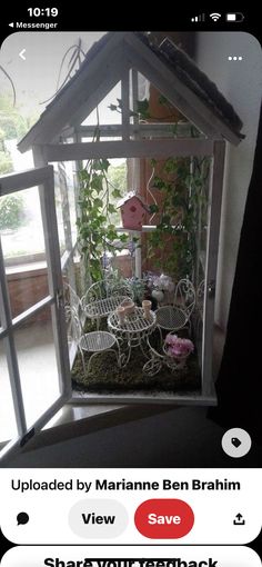 a white birdhouse with plants and furniture inside