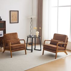 a living room with two chairs and a table in front of a large window,