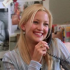 a woman sitting at a desk talking on the phone