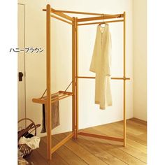 an open closet with clothes hanging on the wall and wooden flooring next to it