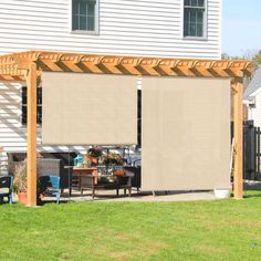 a covered patio with chairs and table in the back yard