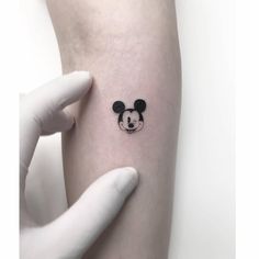 a person with a mickey mouse tattoo on their arm