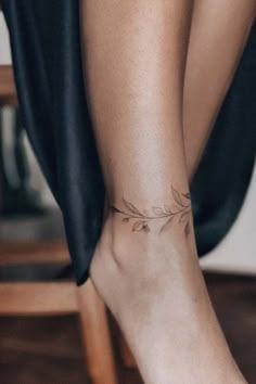 a woman's foot with a small tattoo on the top of her left leg