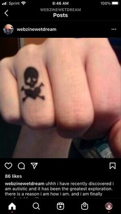 a person with a skull and crossbone tattoo on their thumb, pointing at the camera