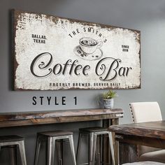 an old fashioned coffee bar sign hangs on the wall above a wooden table and chairs