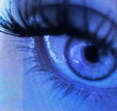 an eye is shown on the screen with blue light coming from it's iris