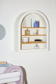 a white sink sitting under a window next to a shelf filled with personal care items