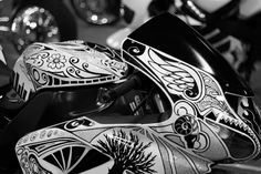 black and white photograph of a motorcycle with intricate designs on the front fender, side view