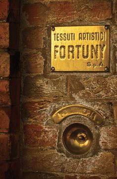 a sign on the side of a brick wall that says, tesuu artisani fortuny spa