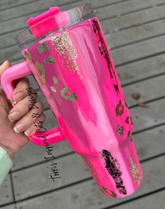 a person holding a pink coffee cup with gold flecks and cactus designs on it