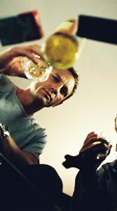 two men are drinking wine from glasses