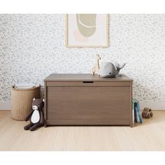 a toy chest sitting on top of a hard wood floor next to a stuffed giraffe