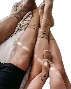 two people laying on top of each other with their legs wrapped in stockings and socks