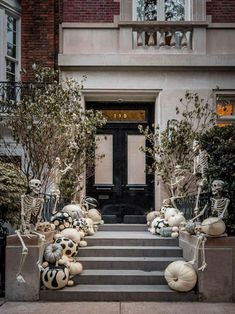 halloween decorations are on the steps in front of a building with black and white pumpkins