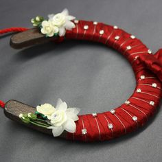 a red headband with white flowers and pearls