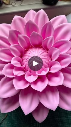 a large pink flower sitting on top of a table