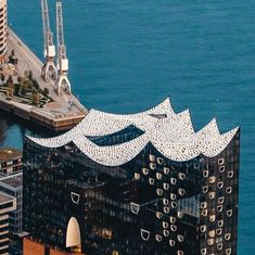 an aerial view of a building in the middle of some water and other buildings around it