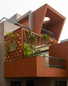 an orange building with plants growing out of it's balconies and balcony