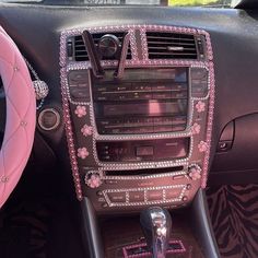 the interior of a car decorated with pink and white flowers, diamond trimmings