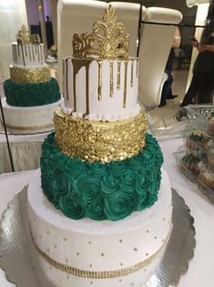 three tiered wedding cake with green and gold icing on display at an event