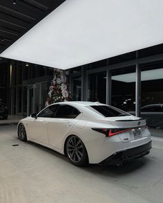 a white car parked in front of a building with a christmas tree on it's roof