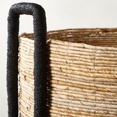 a large woven basket with black handles