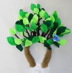 a tree made out of felt with green leaves and blue bird on it's head