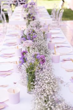 a long table with purple and white flowers on it