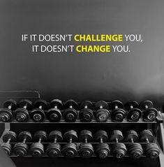 an exercise room with dumbs and a quote on the wall above it that says if it doesn't challenge you, it does't change you