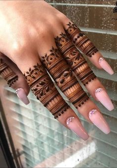 a woman's hand with henna tattoos on it