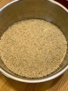 a metal bowl filled with sand on top of a wooden table