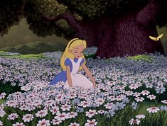 the princess sits in a field full of daisies and looks down at her hand