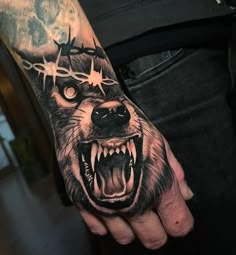 a man's hand with a wolf tattoo on it and stars around his head