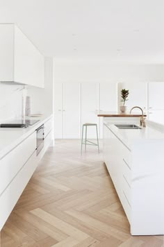 an image of a kitchen with white cabinets and wood flooring on the phone screen