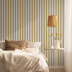 a bedroom with striped wallpaper and white bedding