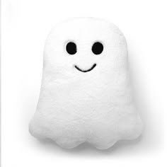 a white pillow with black eyes and a smiling ghost face on it's side