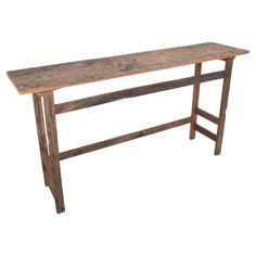 an old wooden table with two legs and a long slab of wood on the top