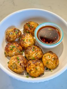 a white plate topped with meatballs and dipping sauce