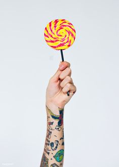 a hand holding a lollipop in the air