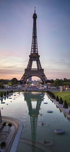 the eiffel tower in paris, france is reflected in a pool of water