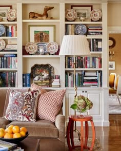 a living room filled with furniture and bookshelves covered in lots of different types of books