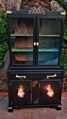 an old china cabinet with glass doors and gold trimmings on the front, painted black