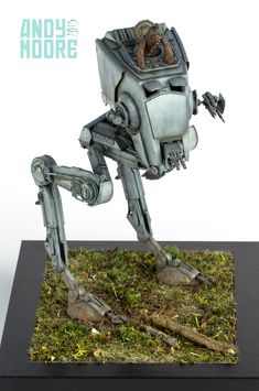 an action figure made out of metal on top of some green grass and wood planks